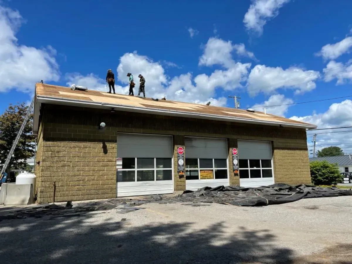 A group of people are working on the roof of a building.