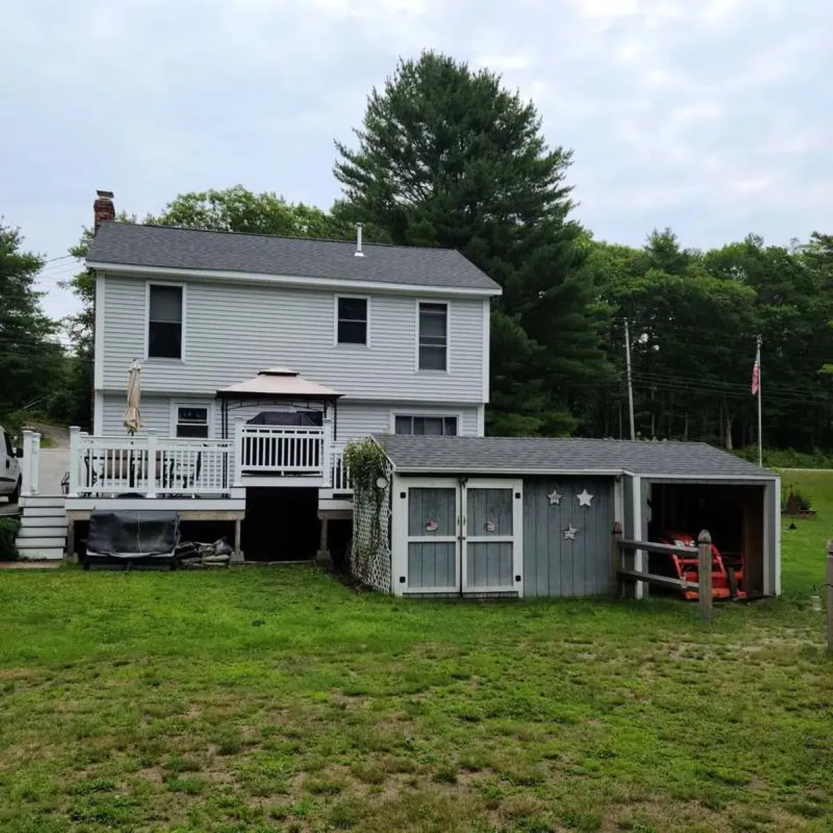 A white house with a shed in front of it