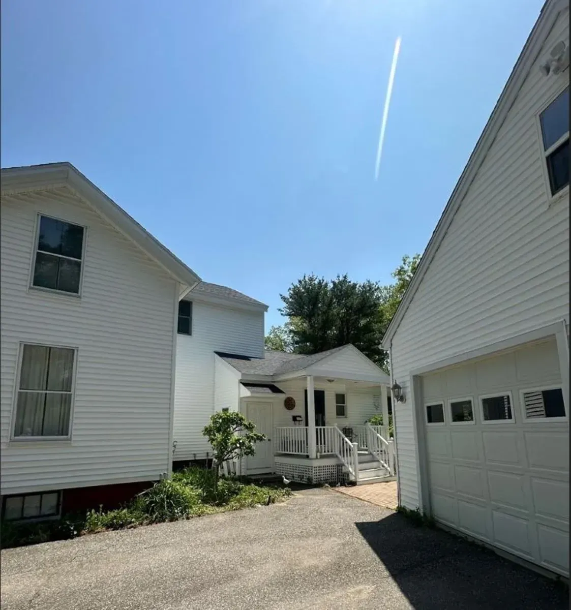 Two white houses are next to each other on a sunny day