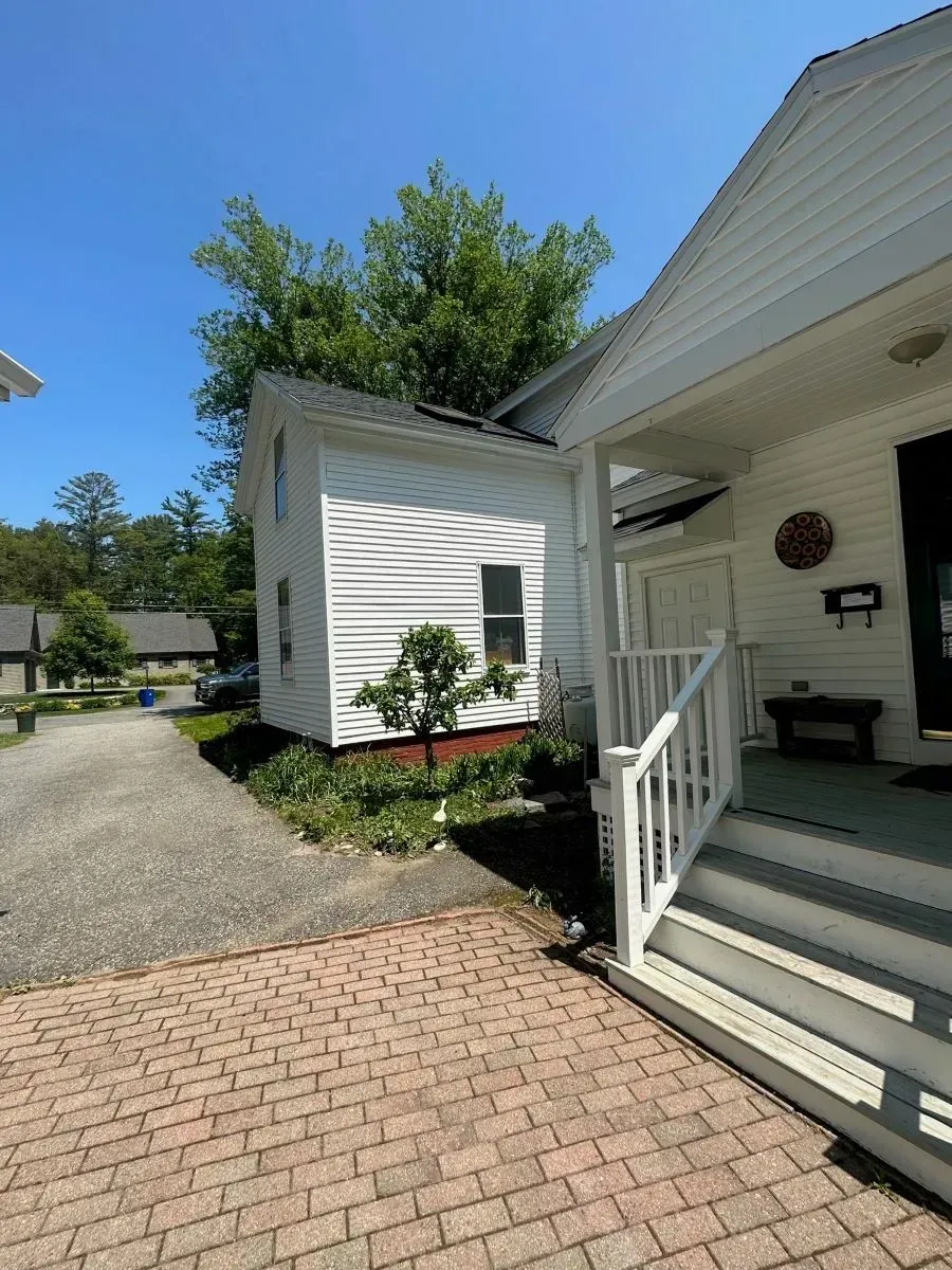 A white house with a porch and stairs in front of it