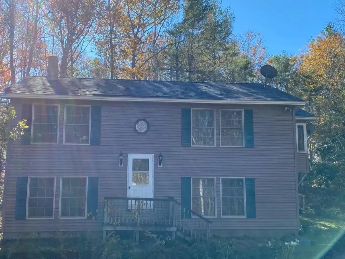 A large house with a lot of windows and a satellite dish on the roof.