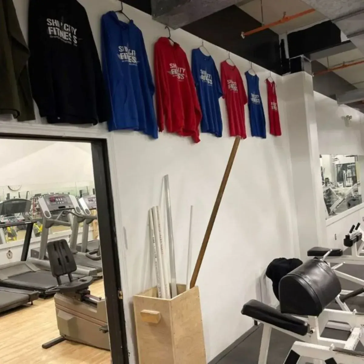 A gym with shirts hanging on the wall that say sunny city fires