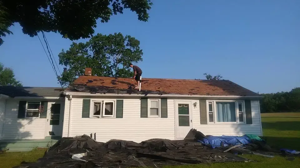 A man is working on the roof of a house