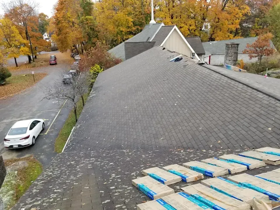 A white car is parked on the roof of a house.