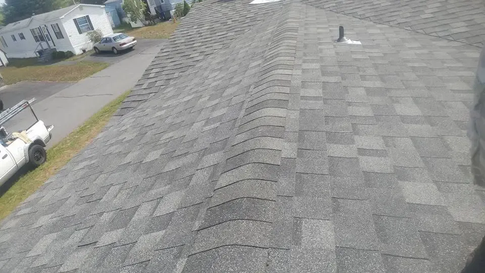 A white truck is parked on the side of a roof.