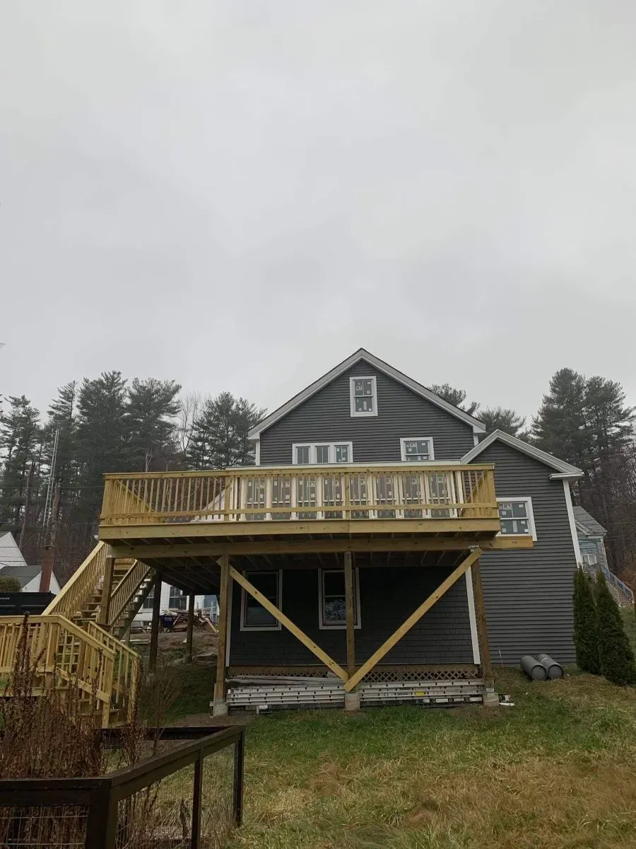 A house with a large deck on the back of it.