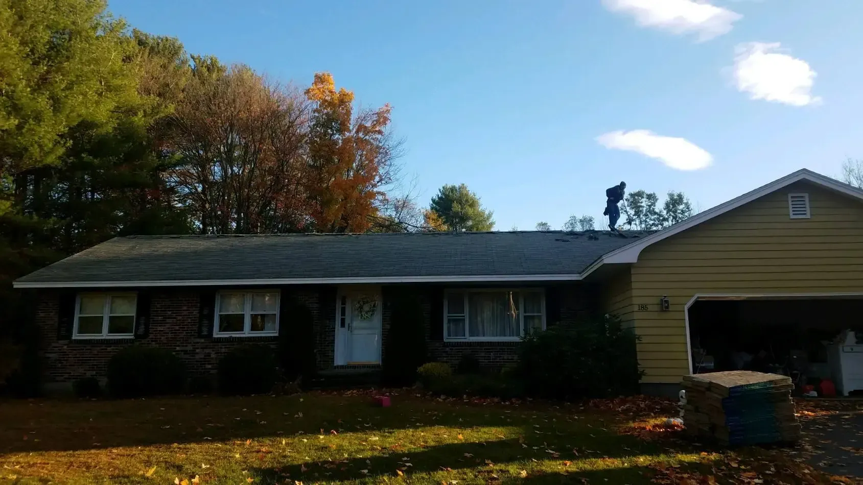 A man is standing on the roof of a house.