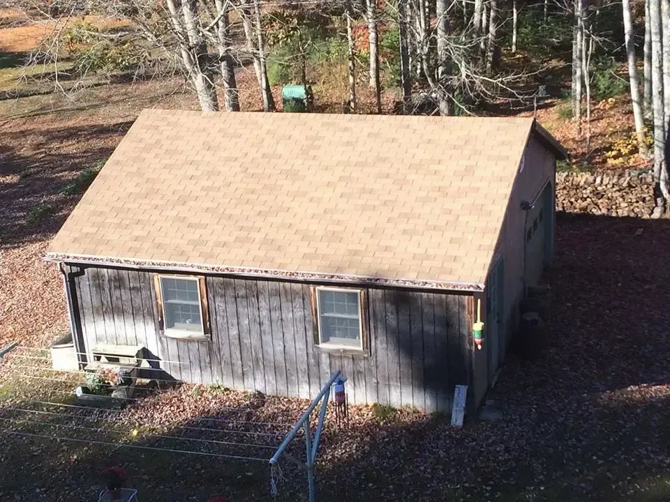 An aerial view of a small house in the woods