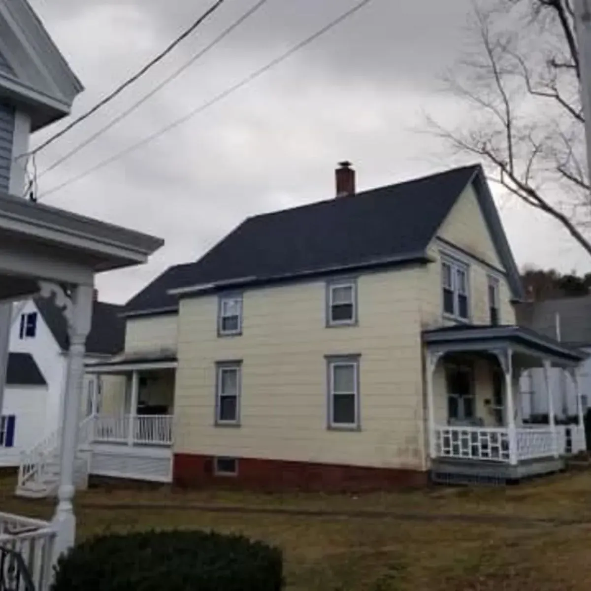 A white house with a black roof and a porch