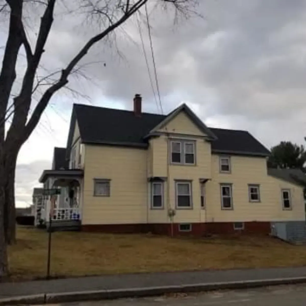 A large yellow house with a black roof