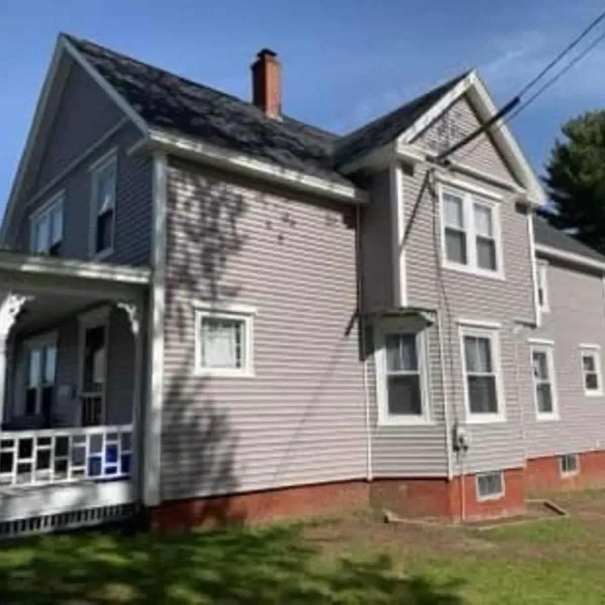 A large house with a porch and a chimney