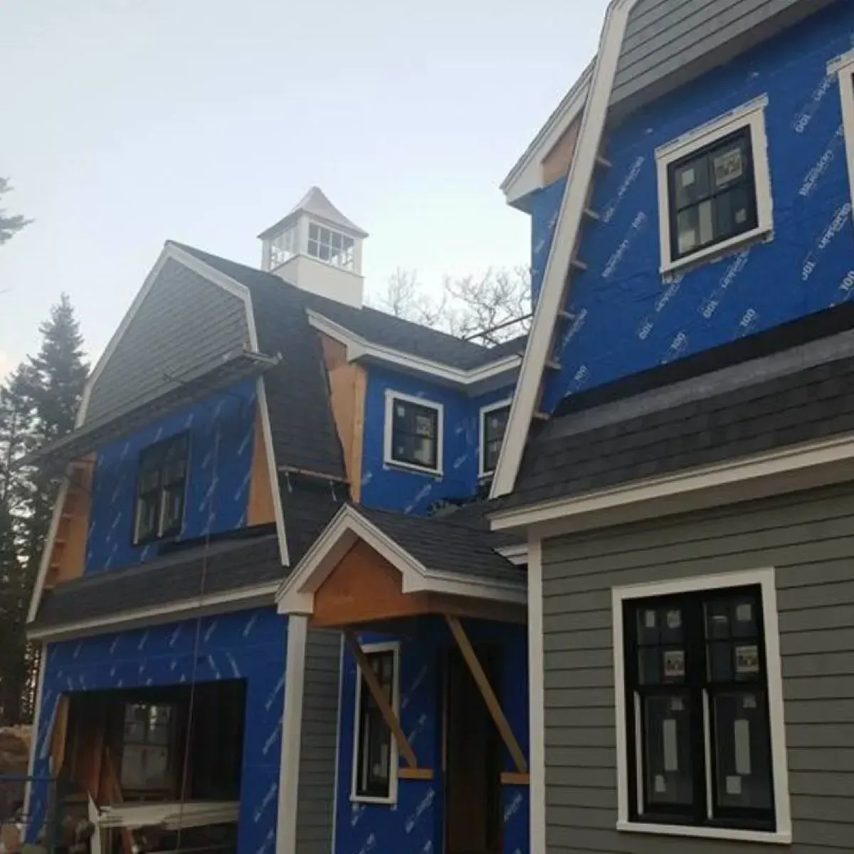 A blue and gray house with a clock tower on top