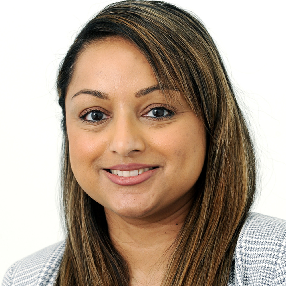 A woman with long brown hair is smiling for the camera