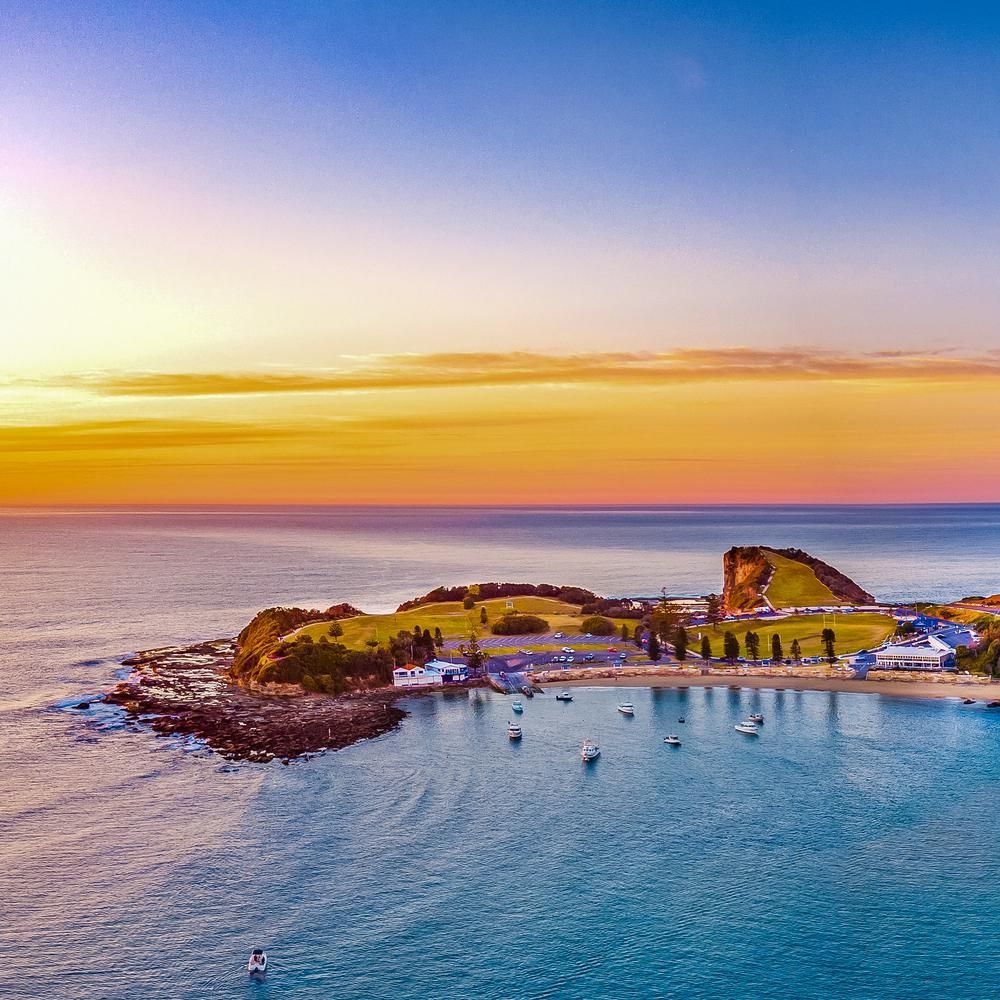 An Aerial View Of A Small Island In The Middle Of The Ocean At Sunset — Nique Building In Gosford, NSW
