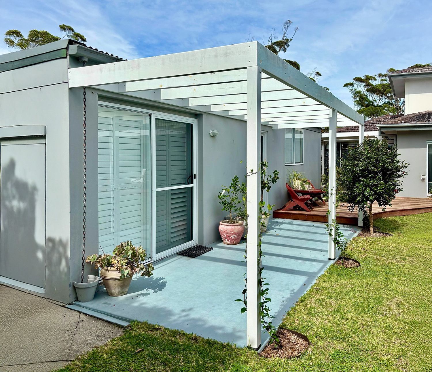 Modern Home Exterior With A White Pergola Over A Patio