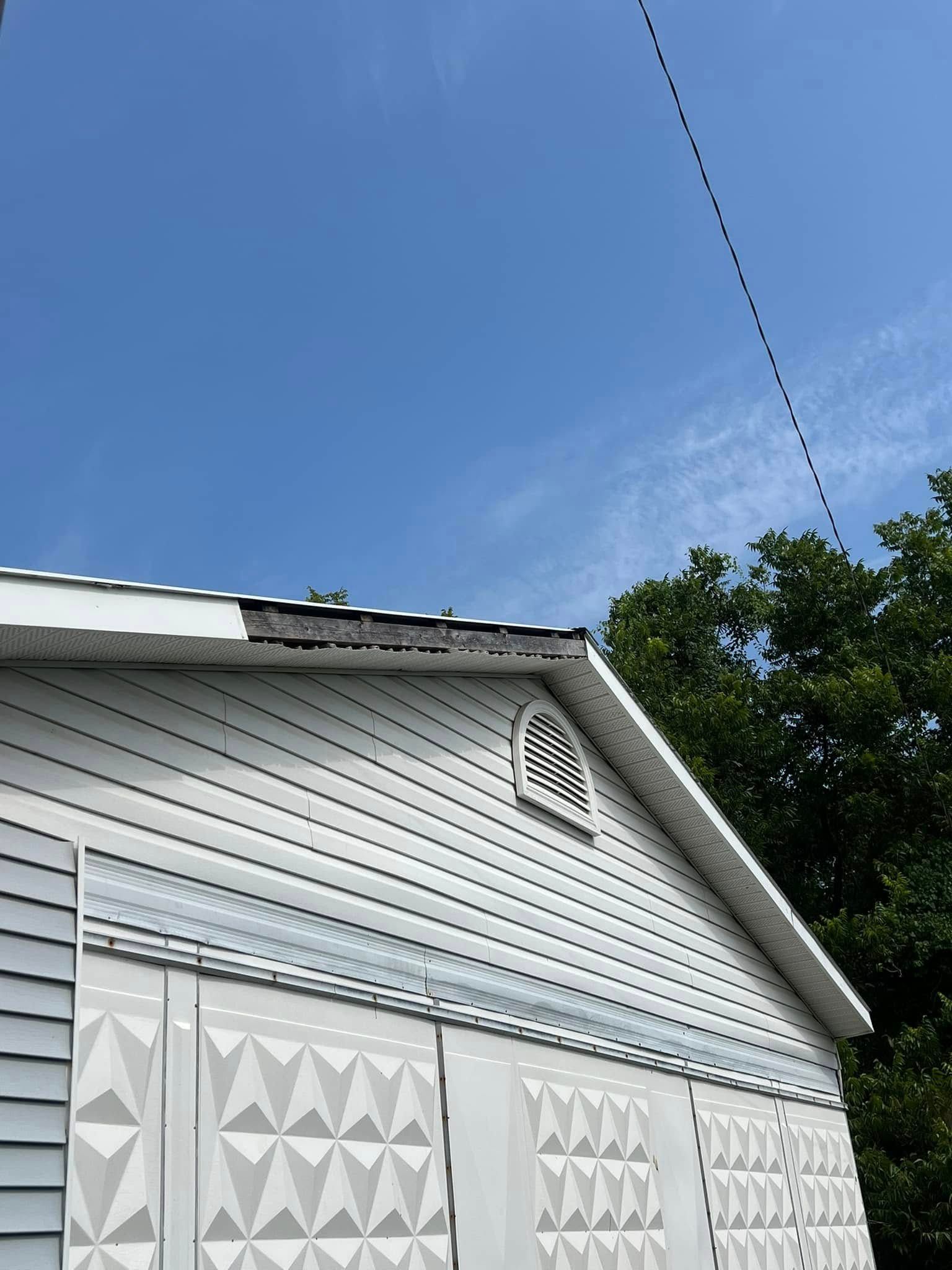 White house exterior with decorative siding, gabled roof, and a blue sky overhead