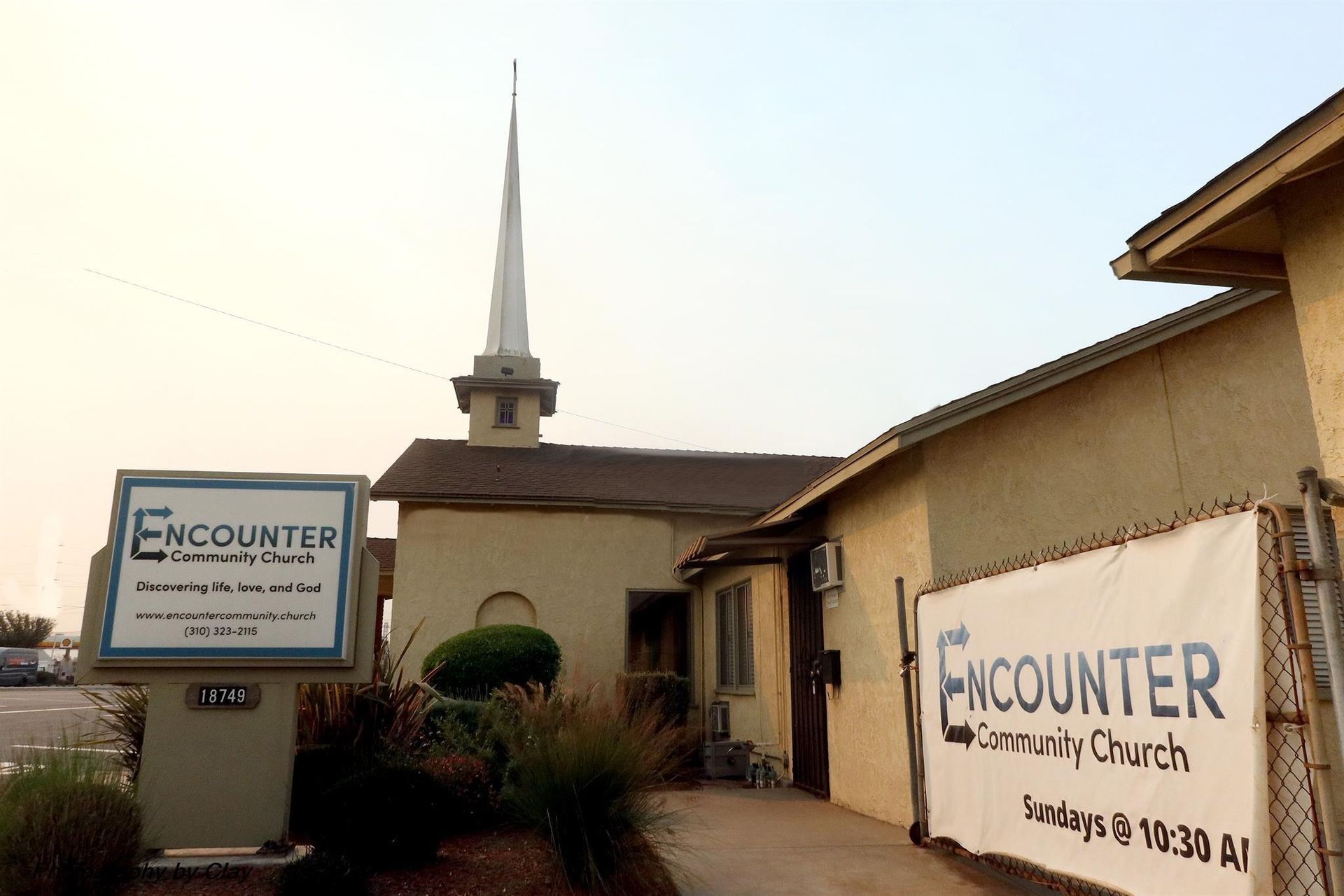 A sign for encounter community church with lollipops in front of it