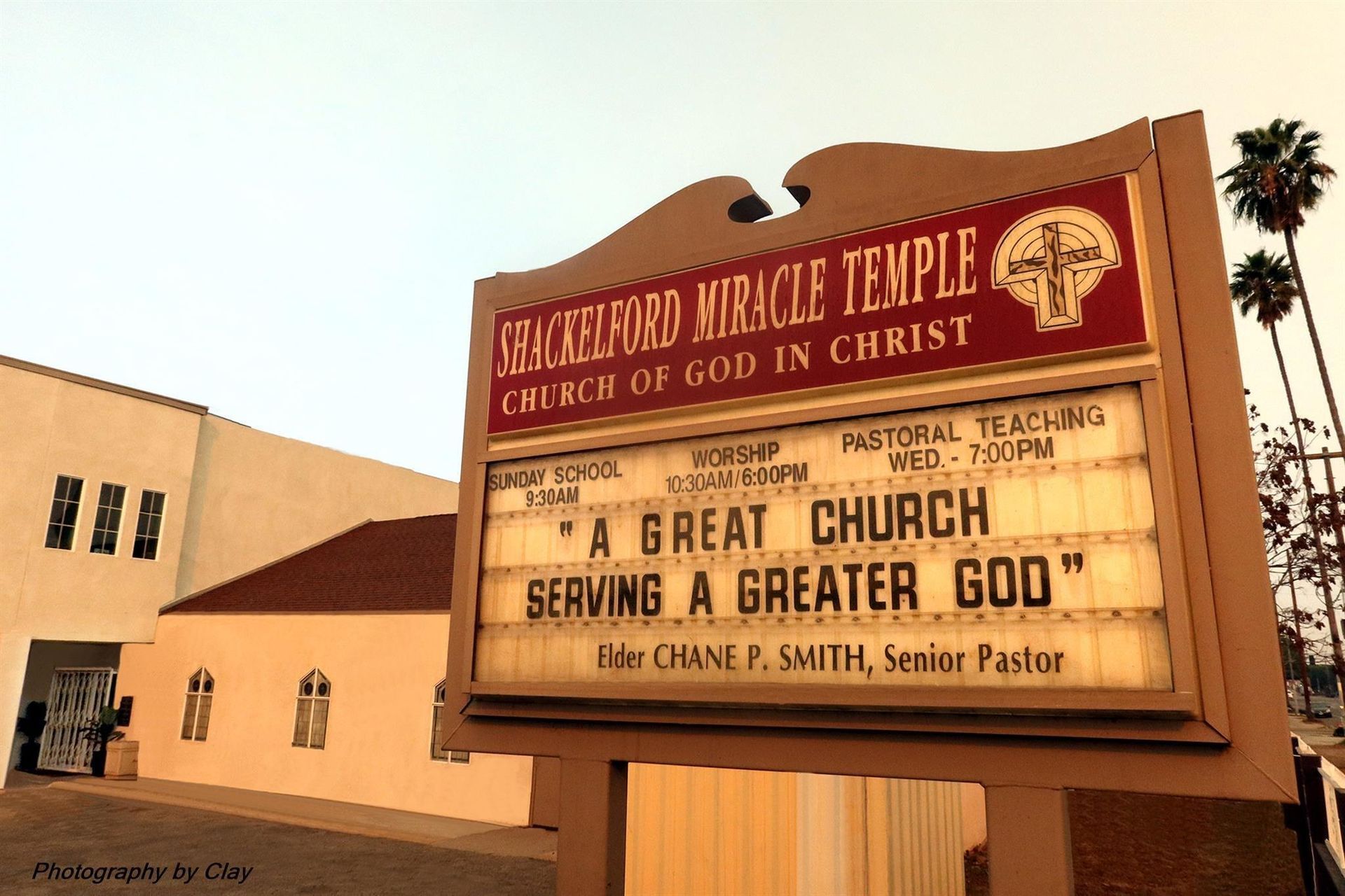 A church with a cross and two televisions on the wall