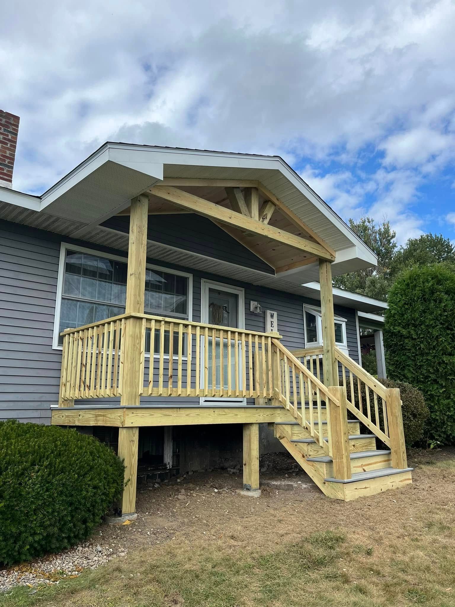 Woman in straw hat smiles, holding wine glass near a lake.