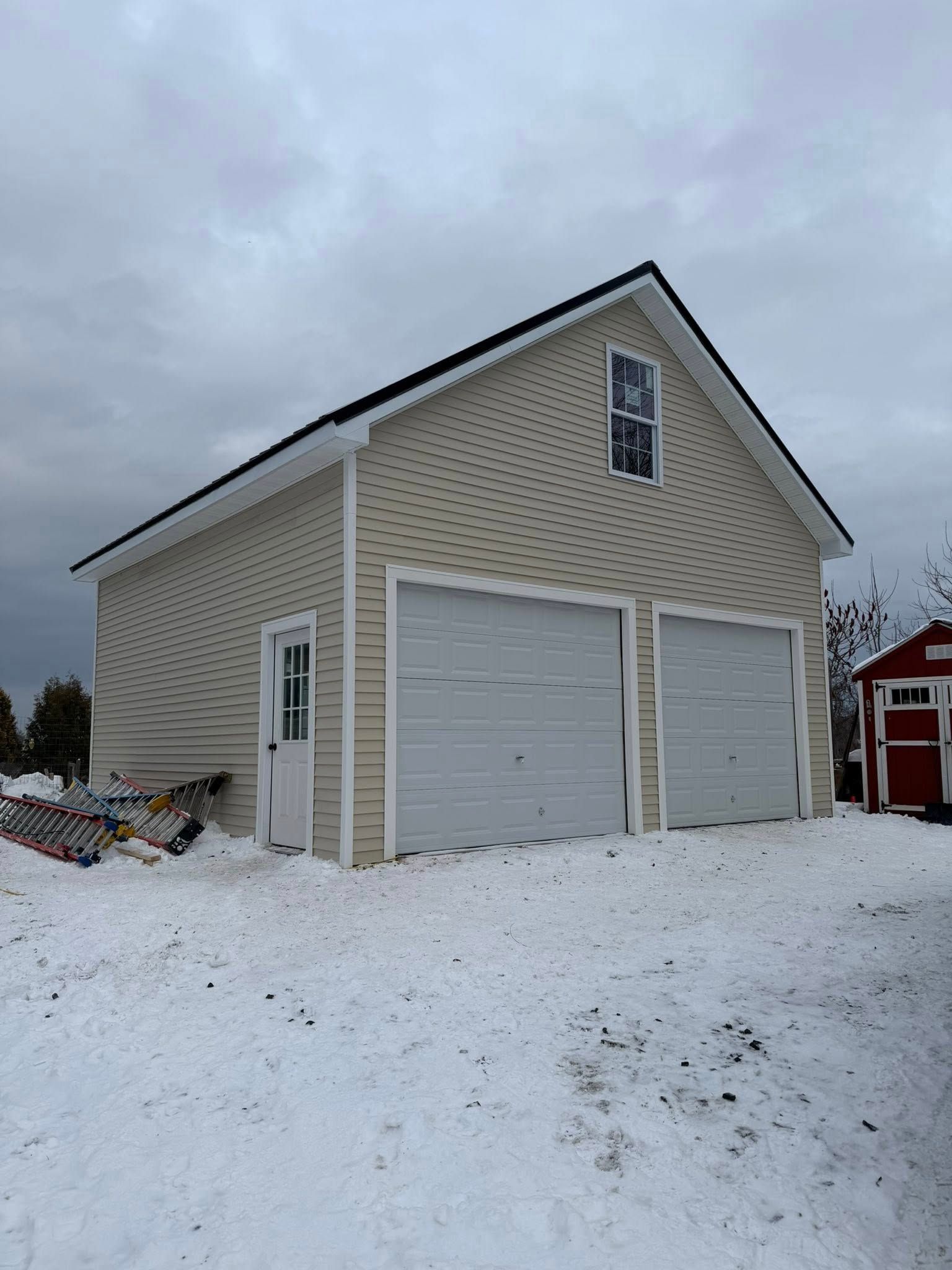 Woman in straw hat smiles, holding wine glass near a lake.