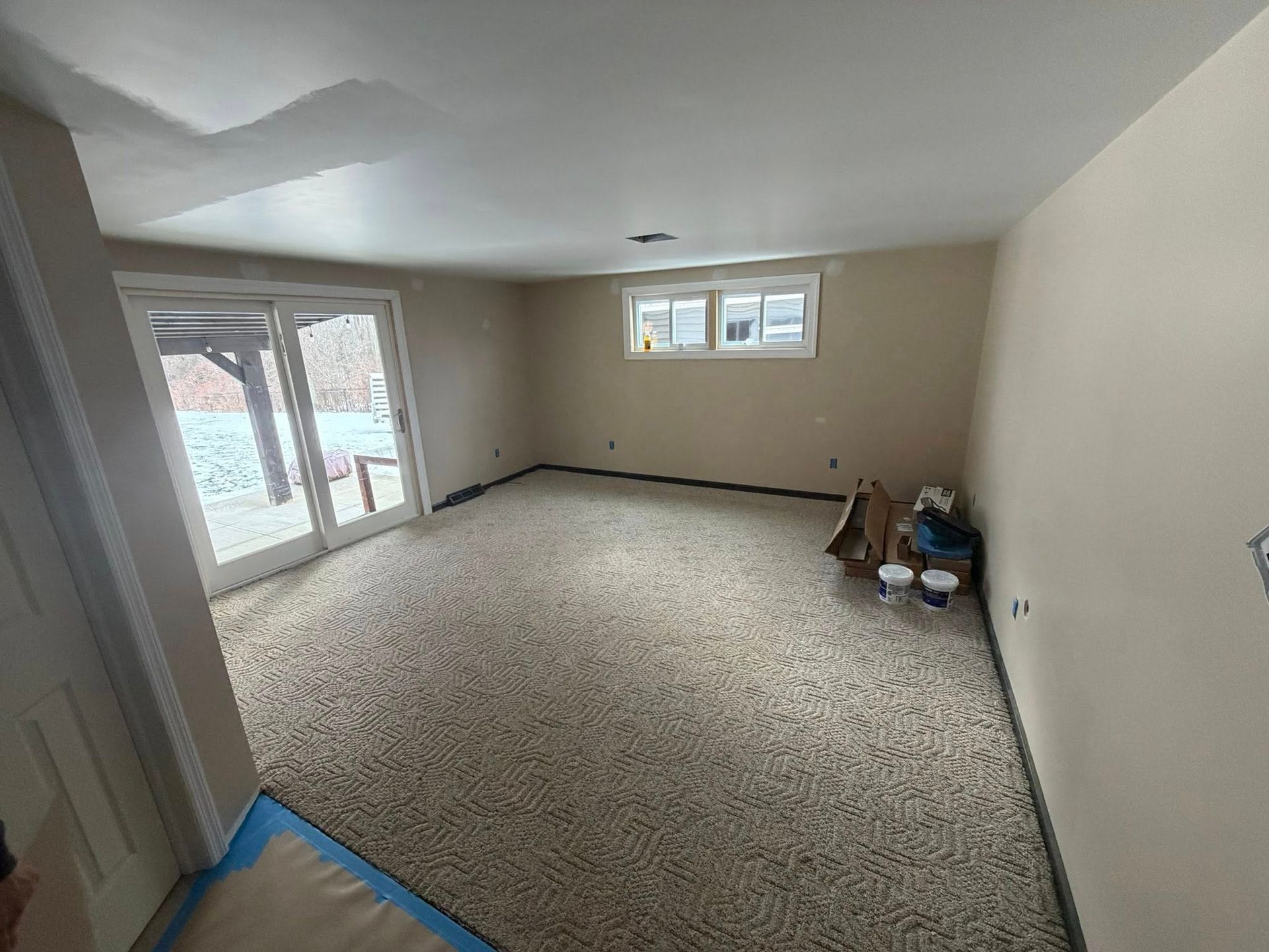 Woman in straw hat smiles, holding wine glass near a lake.