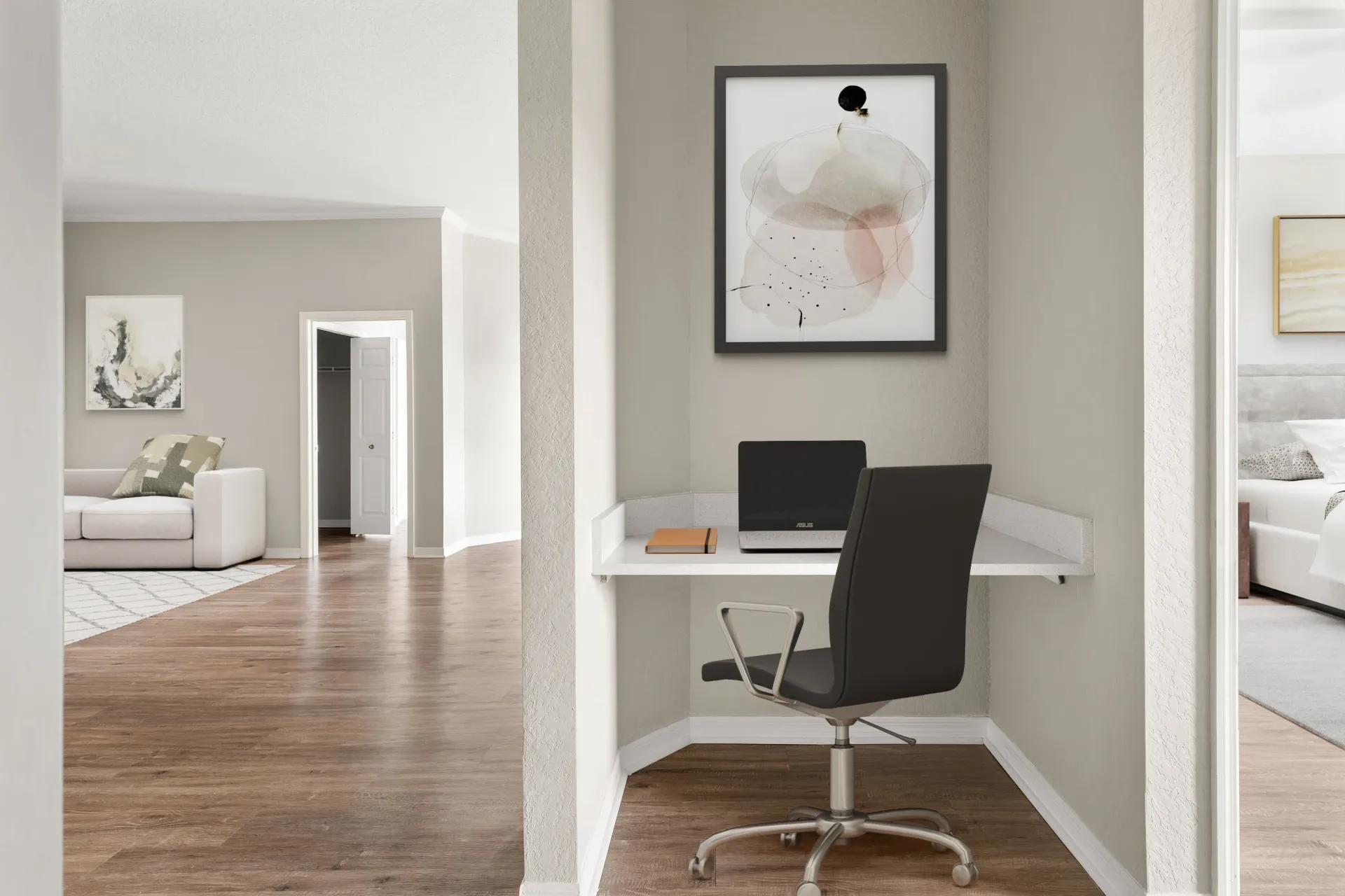 Modern home office nook with desk, laptop, black chair, and abstract wall art in a bright hallway at Levi at River City.