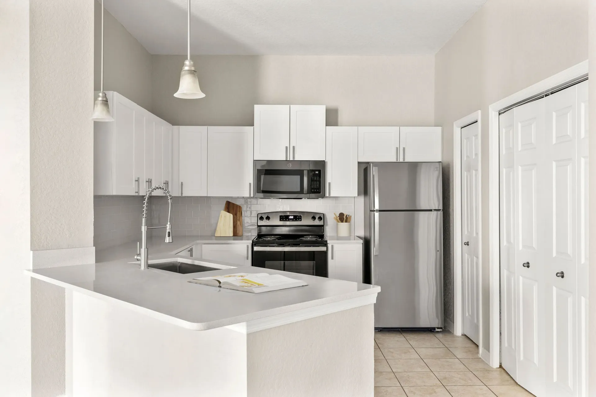A modern kitchen with white cabinets and appliances.