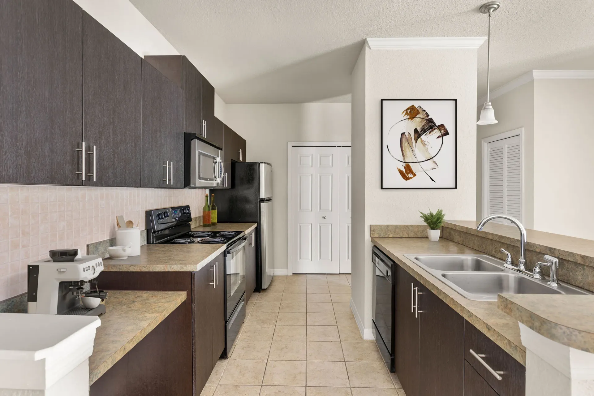 A kitchen with brown cabinets and a black microwave.