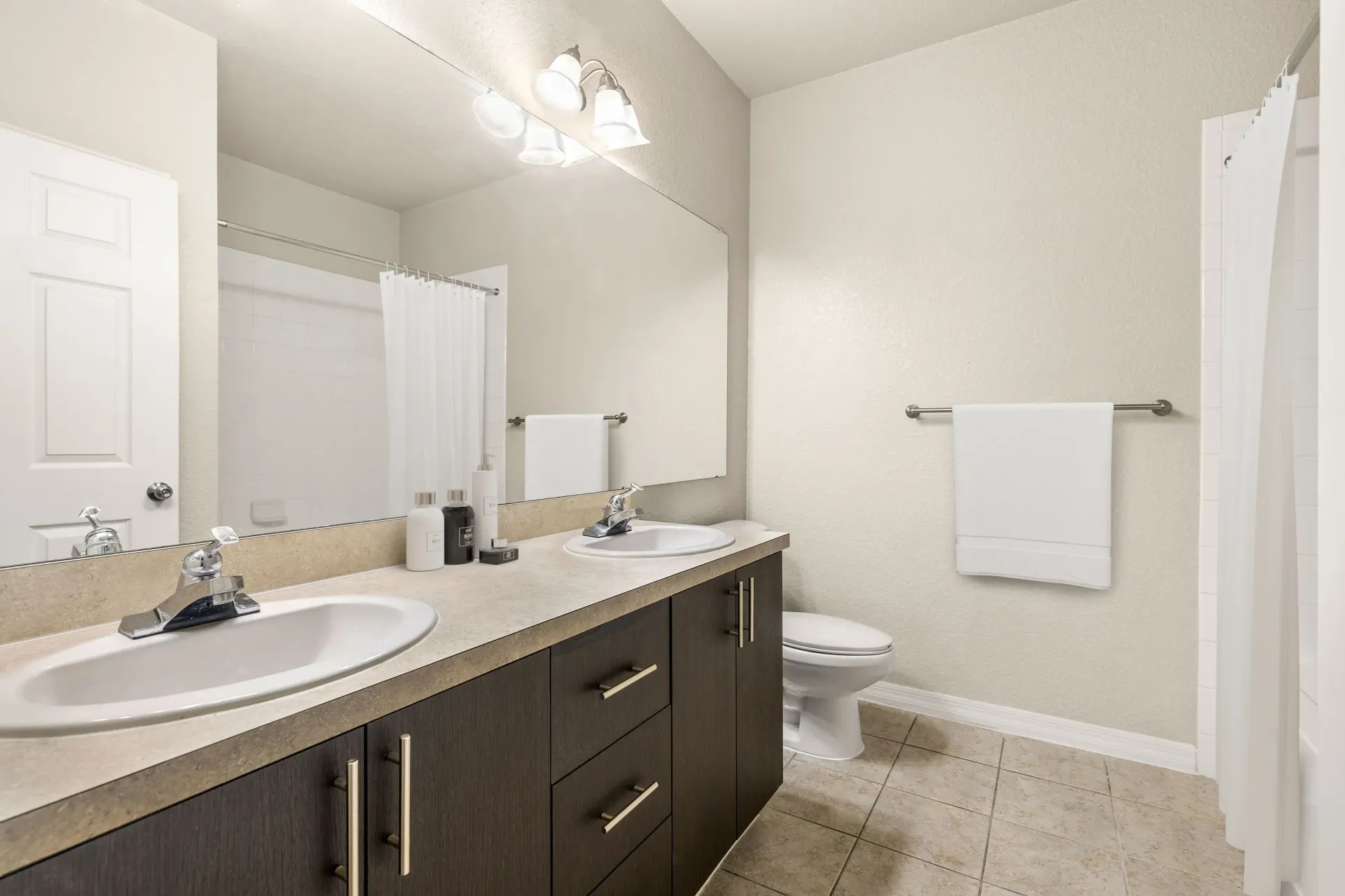 A bathroom with a white sink, toilet, and a mirror.