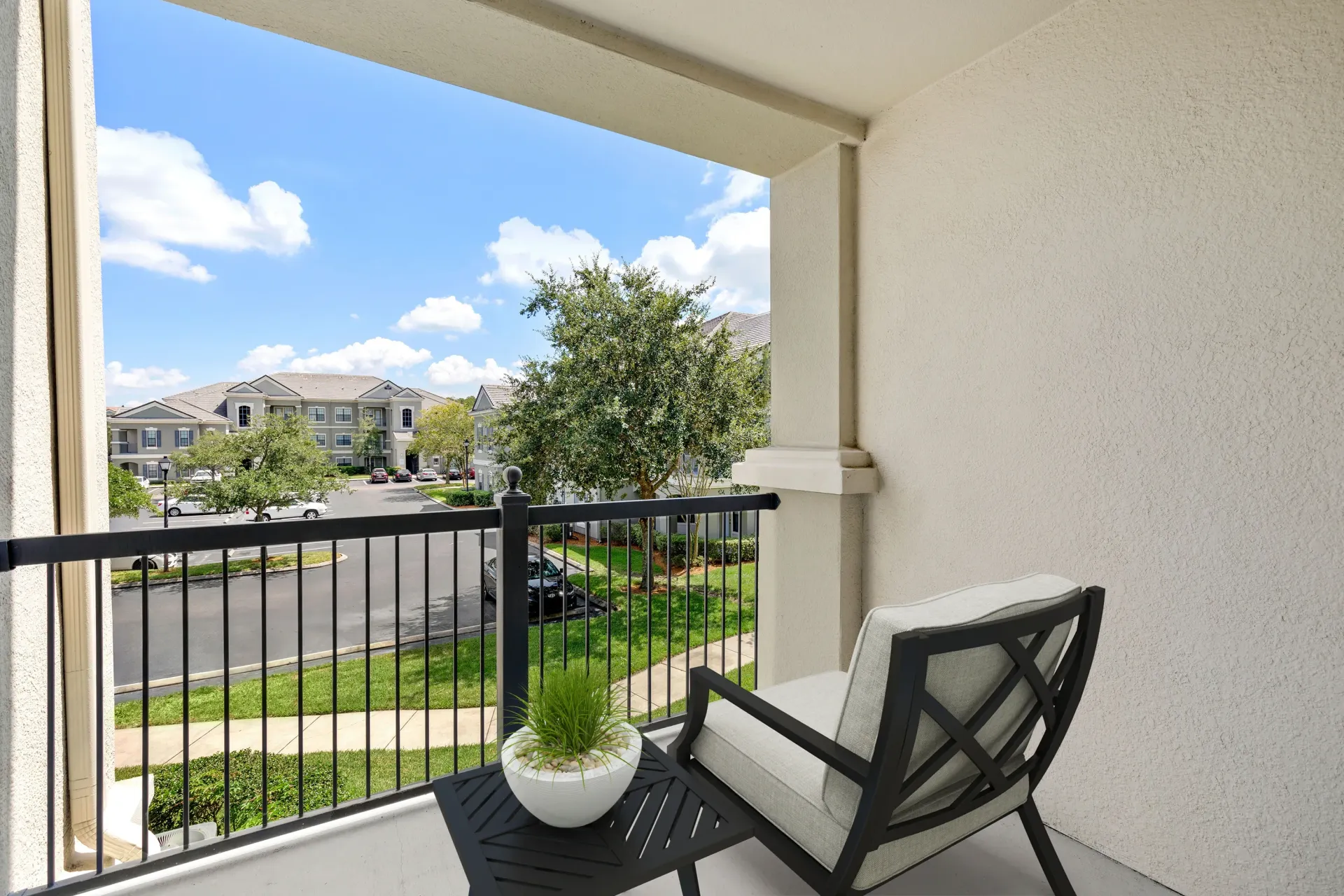 A balcony with a chair and a potted plant.