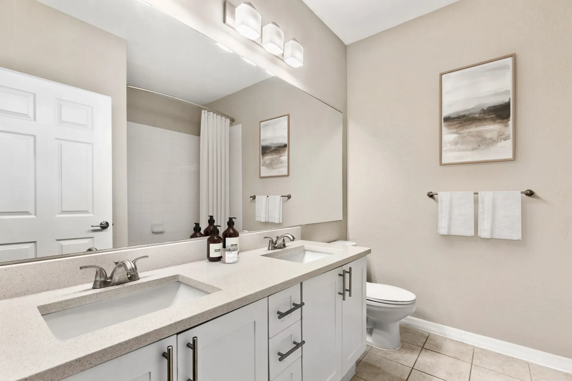 A bathroom with a white toilet, a sink, and a mirror.
