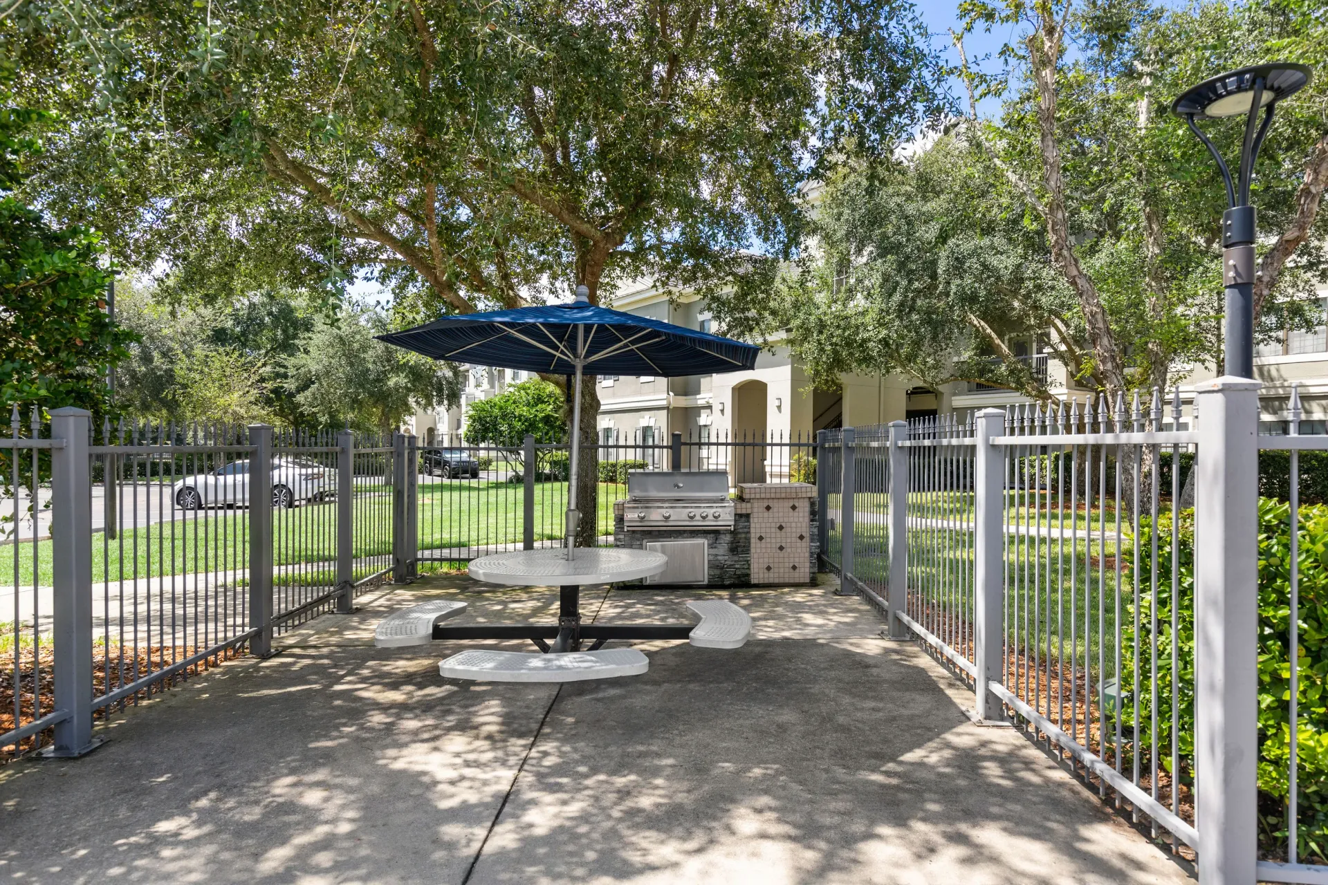 A picnic table is surrounded by a metal fence in a park.