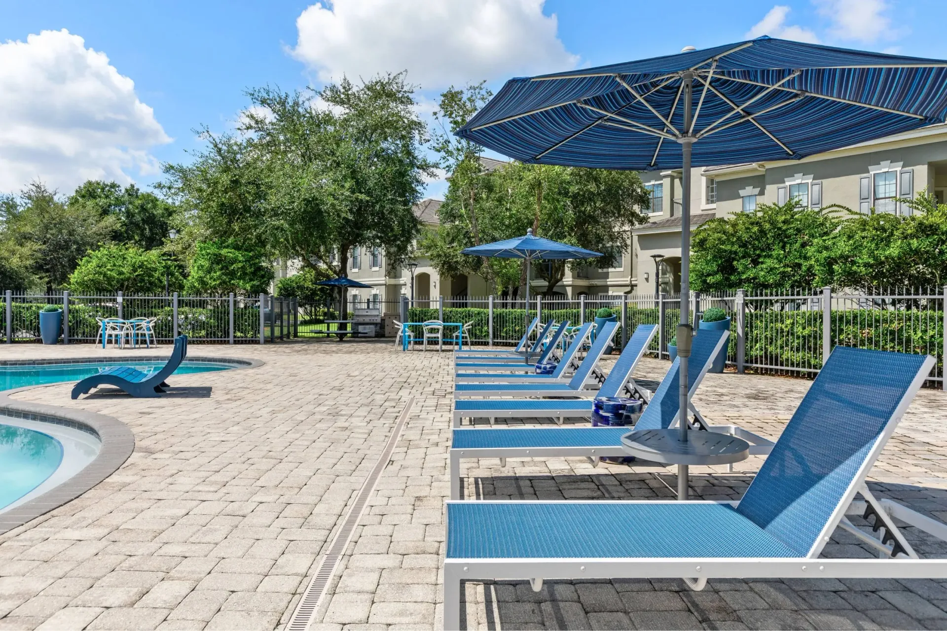 Outdoor swimming pool area with lounge chairs and umbrellas