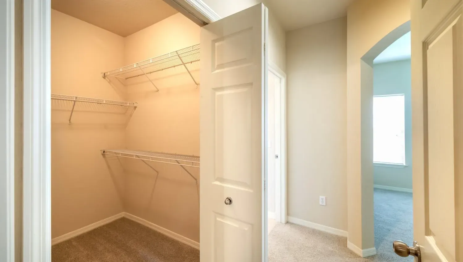A small, empty room with a doorway leading to another room at Levi at River City.