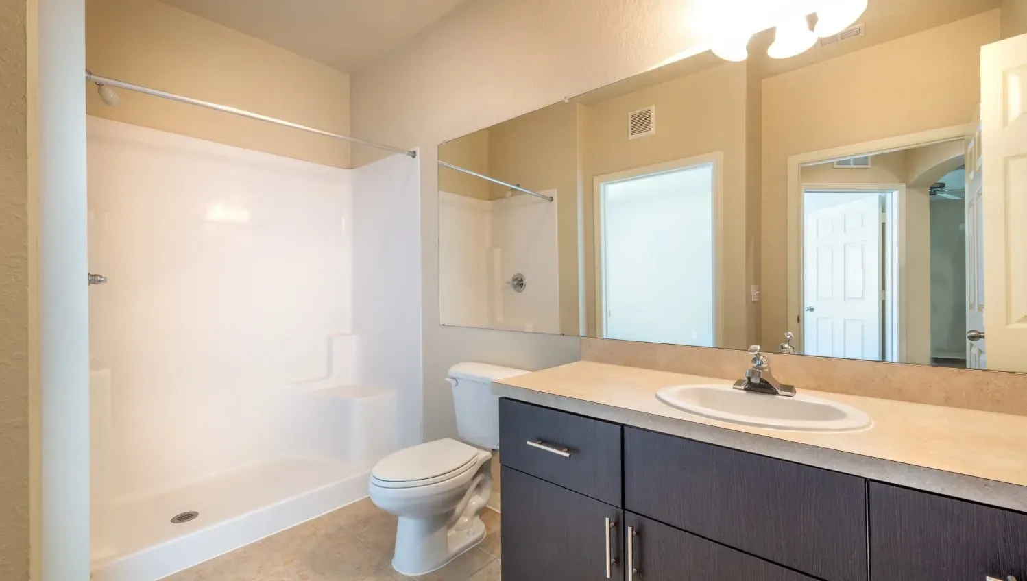 A bathroom with a toilet, sink, and mirror.