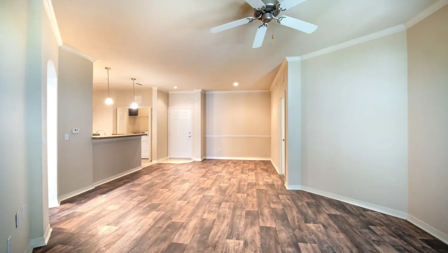 A room with a ceiling fan and lighting fixtures at Levi at River City.