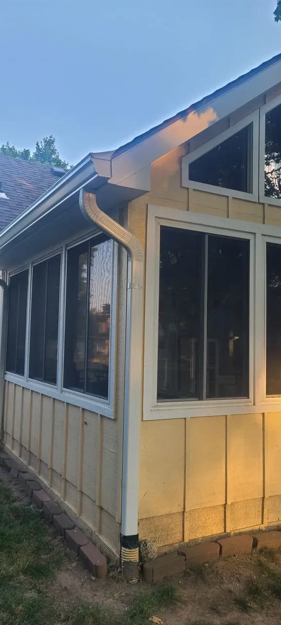 A house with a screened in porch and a lot of windows.