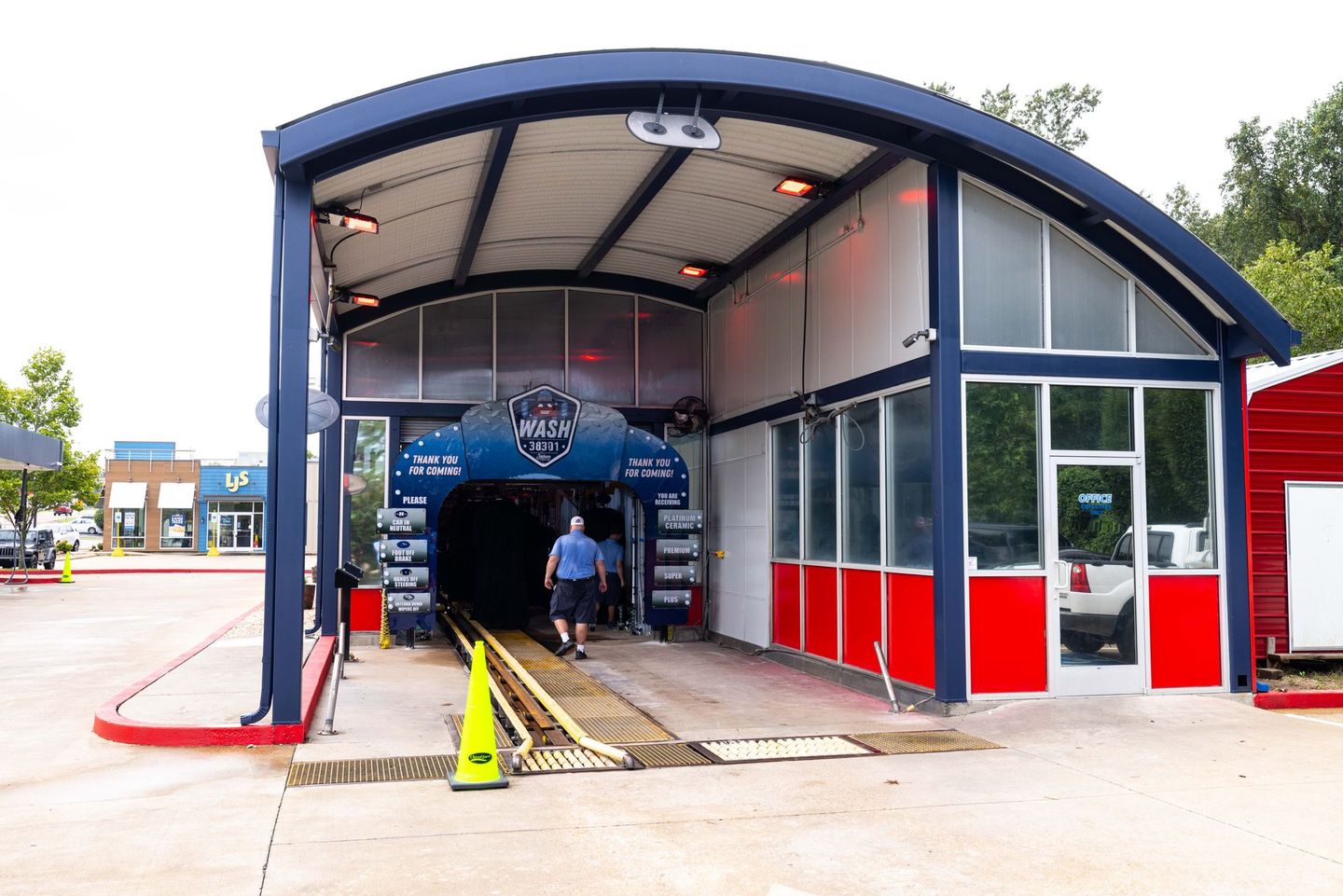 A man is walking out of a car wash tunnel