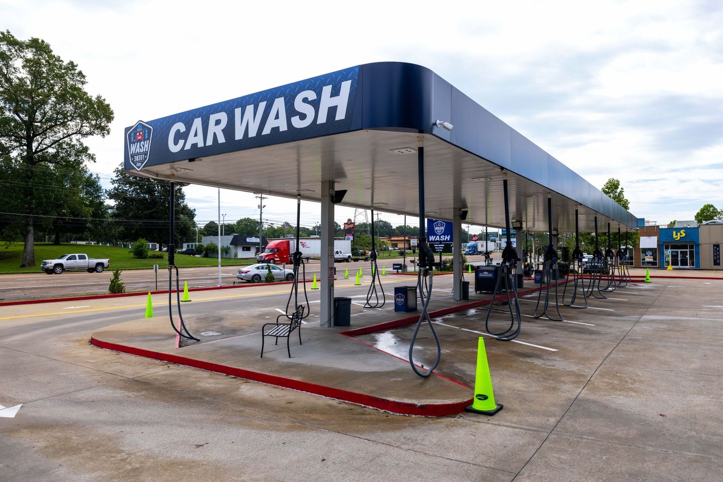 A car wash is located in the middle of a parking lot.