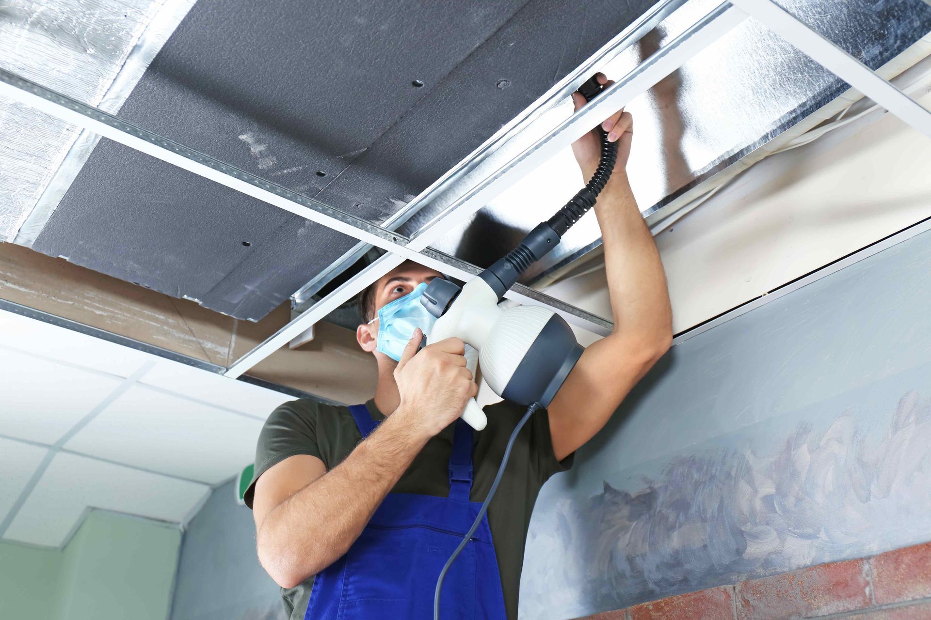 A man cleaning an air duct with machine