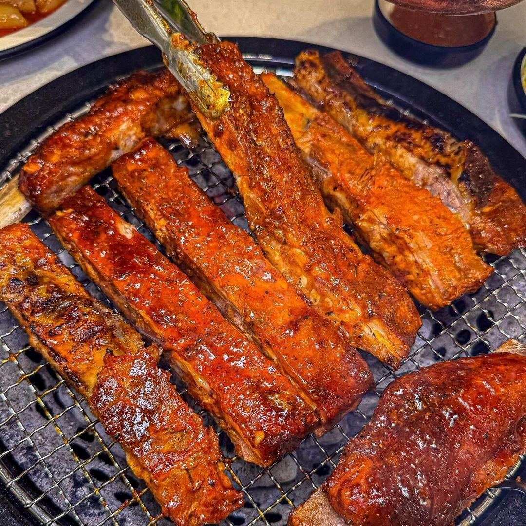 Juicy Texas ribs grilling at Yukmijedang in Daegu, showcasing the deliciously glazed ribs being cooked to perfection.