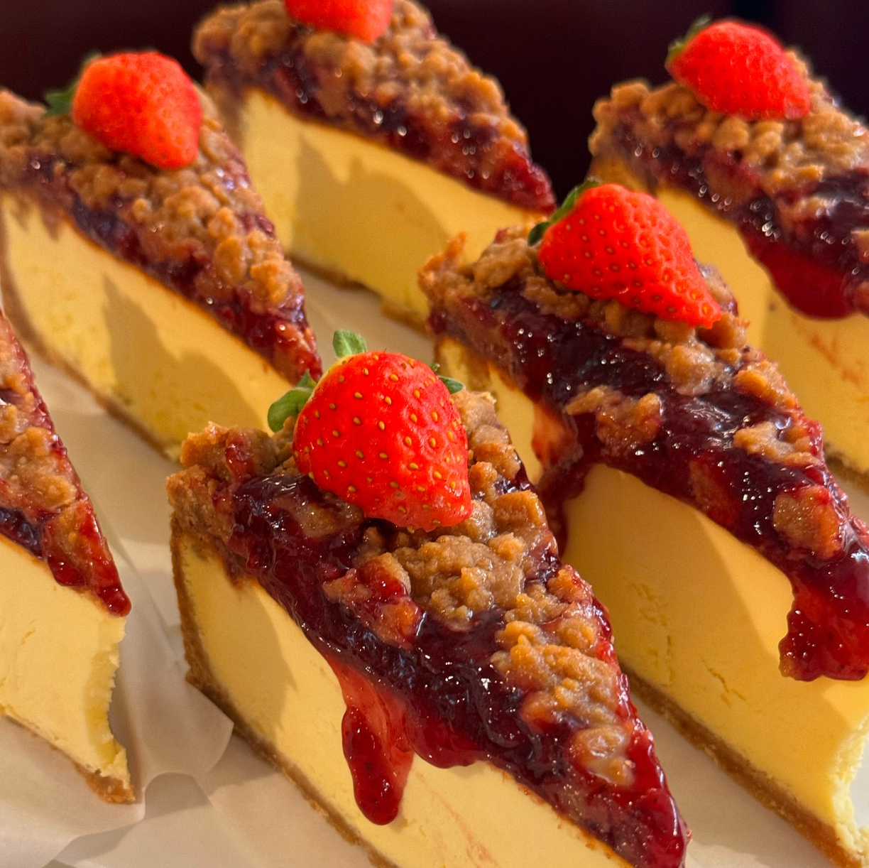 Slices of strawberry crumble cheesecake topped with whole strawberries at Western Chapter café near Seoul Forest