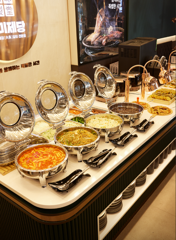 A buffet spread at Yukmijedang in Daegu, featuring a variety of Korean dishes including kimchi, japchae, and various vegetables.