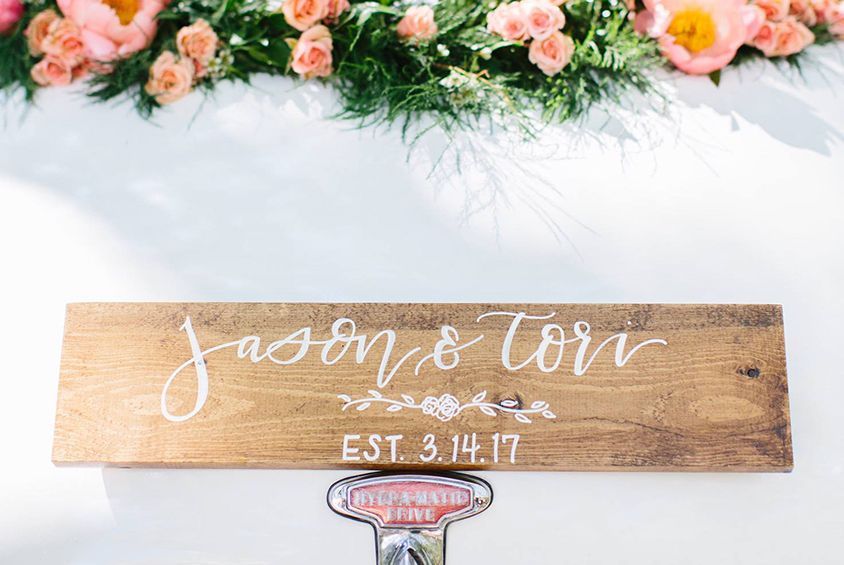 A wooden sign with the names jason and tori written on it is sitting on a table.