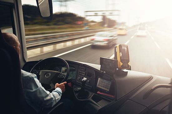 A man is driving a bus on a highway.