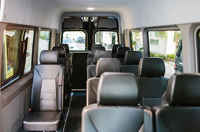 The inside of a van with lots of seats and windows.