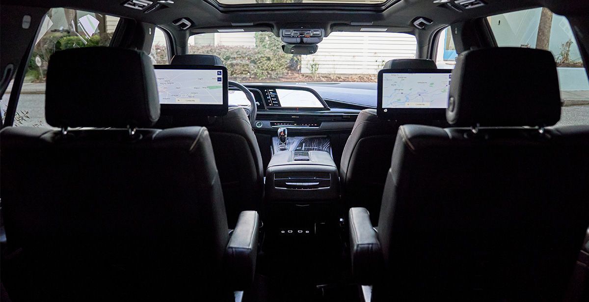 The back seat of a car with two monitors on the headrests.