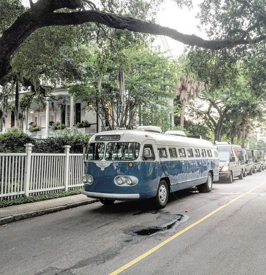 A blue and white bus is parked on the side of the road