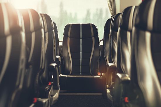 The inside of a bus with empty seats and a window.