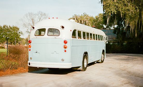 A white bus is parked on the side of a road.